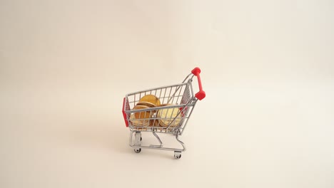 Hand-pushing-a-shopping-cart-full-of-coins