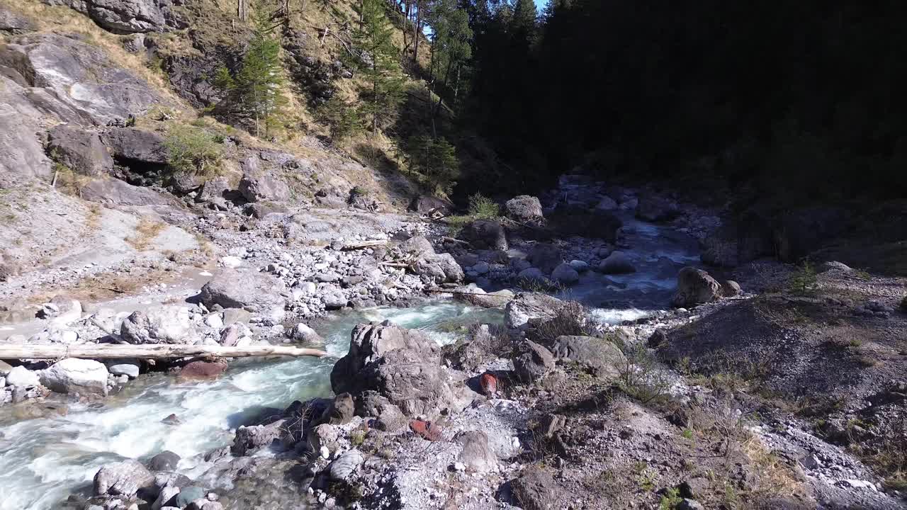 un dron vuela sobre un río con aguas cristalinas de color turquesa en un valle montañoso en austria, europa