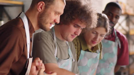 man cooking pasta with help of chef during culinary class