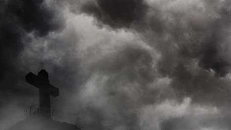 silhouette cross on rock mound with thunderstorm background