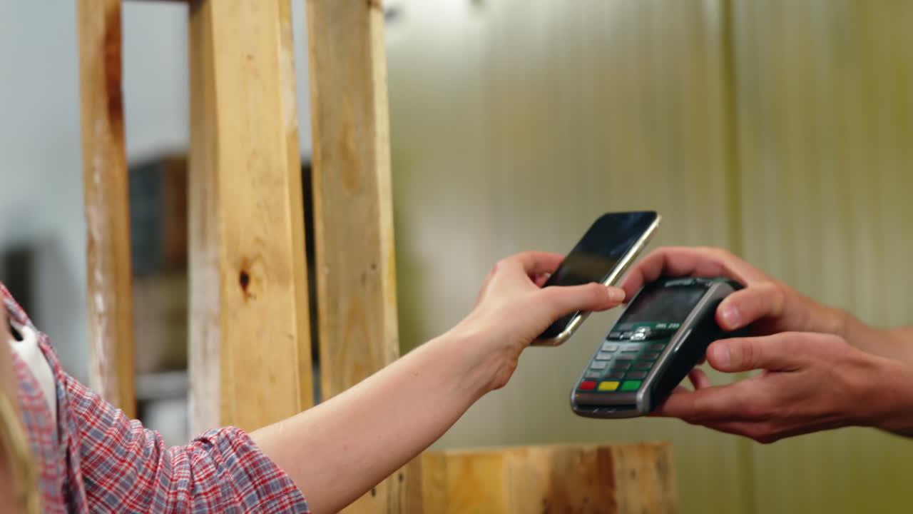 Woman paying bill through smartphone using NFC technology