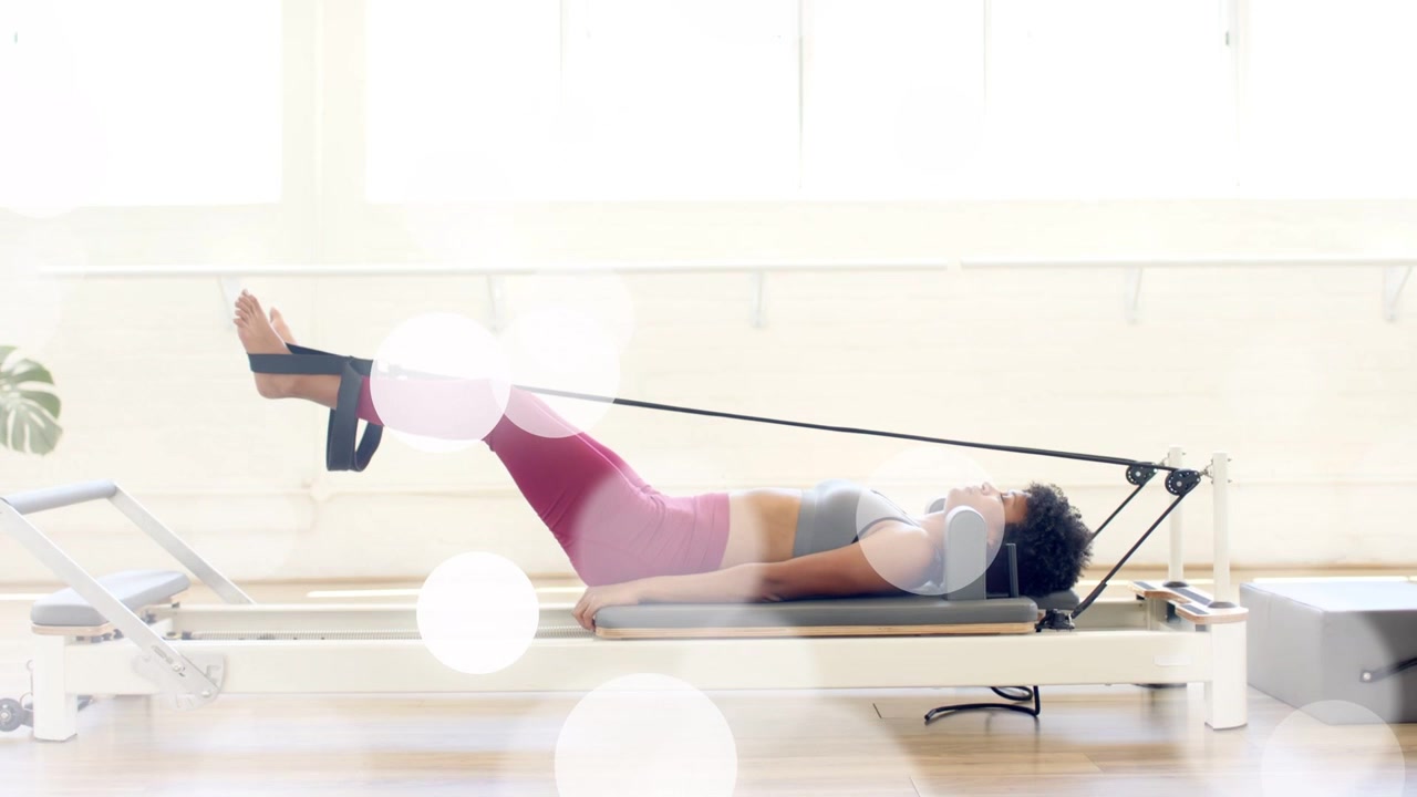 Donna che fissa le cinghie per i piedi e ripete esercizi per le gambe sul reformer, linee animate che mostrano la tonificazione Pilates.