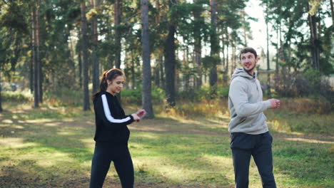 couple exercising outdoors in the autumn forest