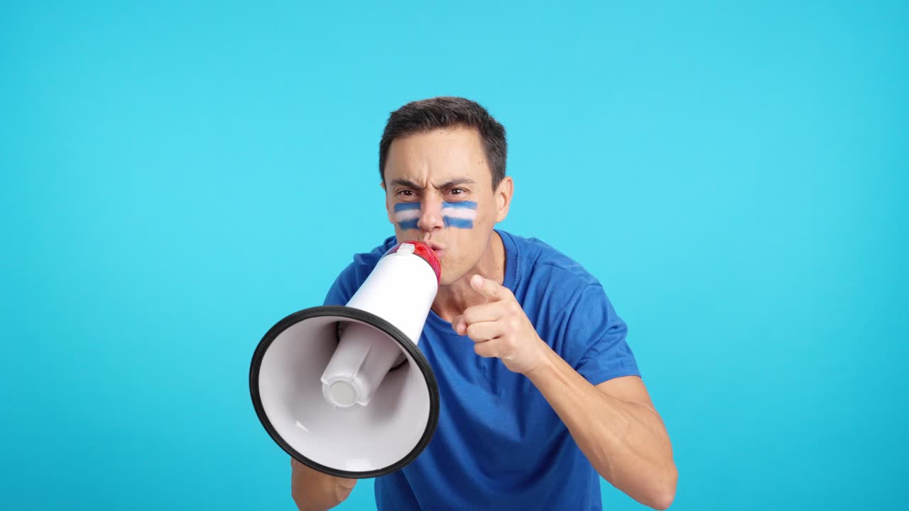Excited man with salvadoran flag on face using a megaphone