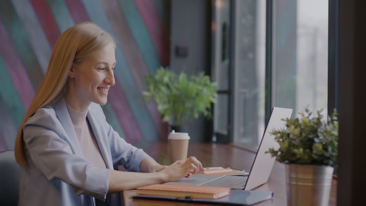 Donna che lavora al computer portatile in un caffè