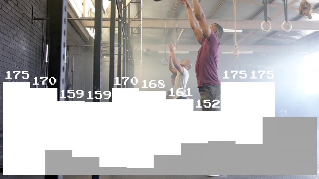 In gym, men exercising with medicine balls over animation of bar graph