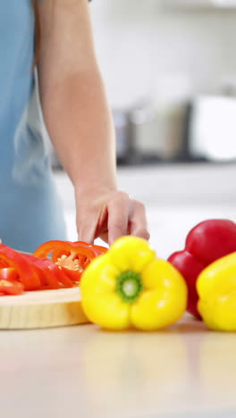 mujer preparando verduras en la tabla de cortar