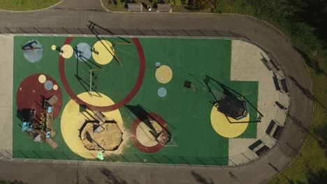 A-colorful,-empty-playground-stands-in-the-midst-of-a-lush-green-urban-park-during-the-summer-in-Poland