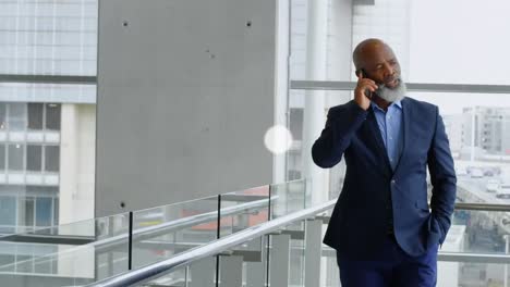 network of digital icons against african american senior businessman talking on smartphone at office