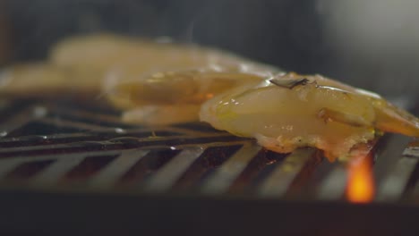 Drizzling-marinade-over-a-skewer-of-shrimp-prawns-on-a-wood-fire-grill-at-a-restaurant---isolated-close-up
