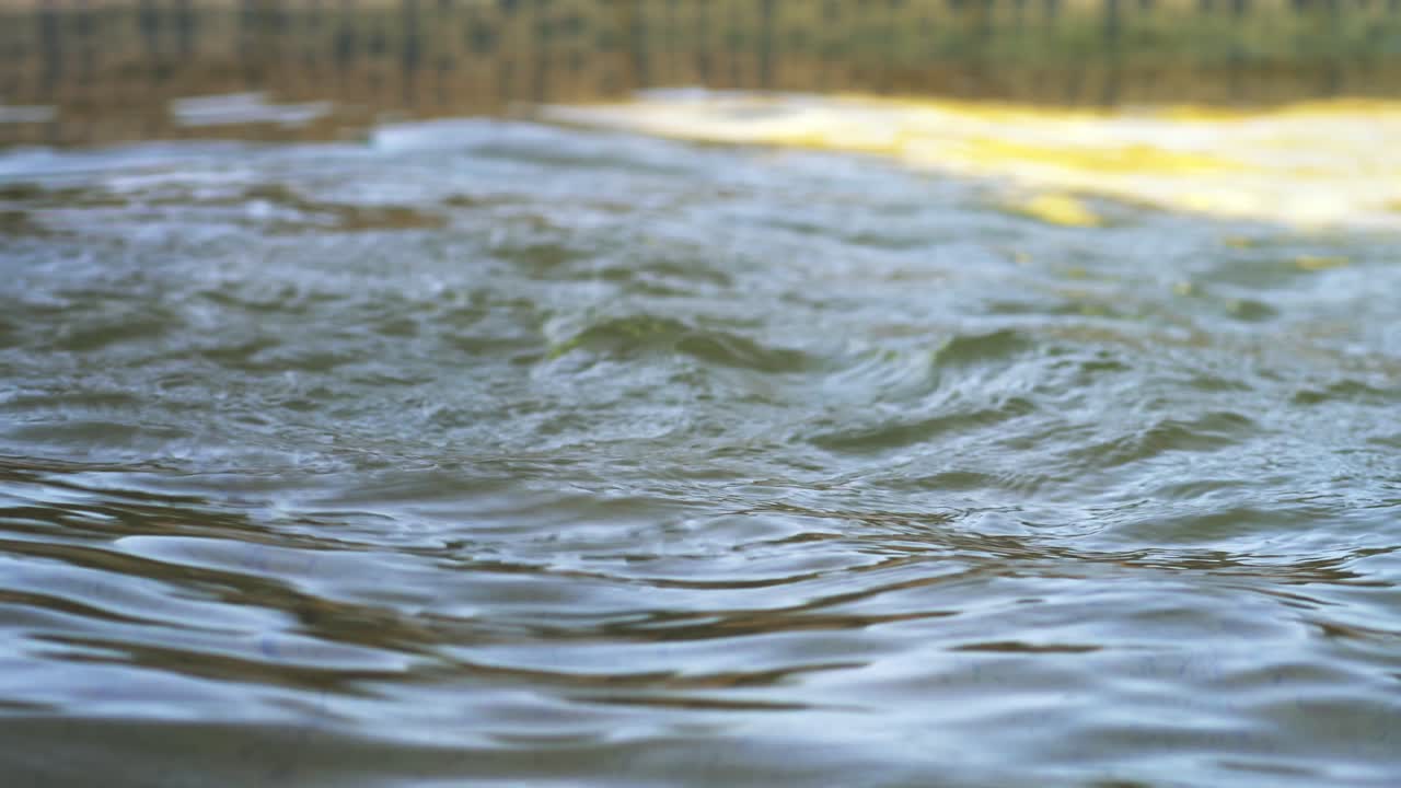 Close-up of water surface ripples on an outdoor swimming pool.