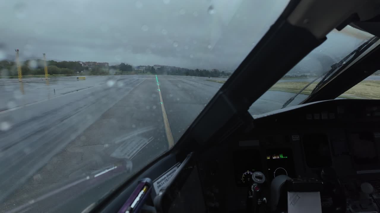 Hyperlapse immersivo ripreso dalla cabina di pilotaggio di un jet mentre rulla attraverso le vie di rullaggio dell'aeroporto sotto un cielo tempestoso, e si allinea alla pista pronto per la partenza