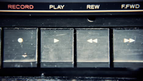 a finger pressing the keys of an old retro vintage cassette tape player