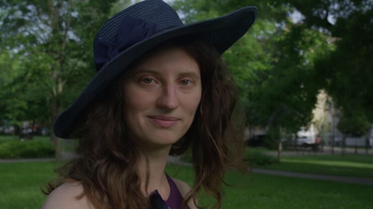 une belle jeune femme avec un chapeau bleu flirte avec la caméra