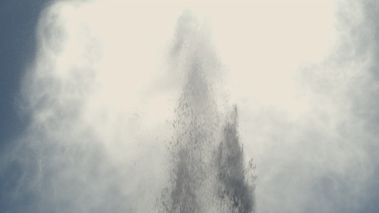 Slow motion sea spray bursts upward, creating dramatic plumes in the air under clear daylight