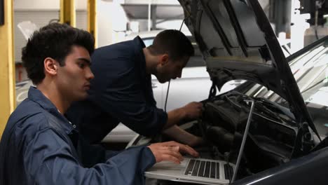 Handsome-mechanics-overhauling-a-car