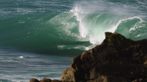 heavy wave breaking in slow motion barrels along a shallow reef