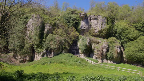 extra wide shot looking north of the limestone gorge with caged entrance to the caves at creswell crags