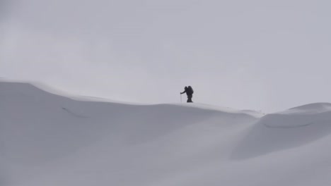 Lone-person-ski-touring-along-mountain-ridge-in-winter