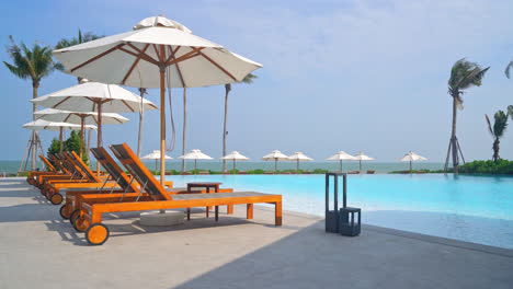 umbrella with bed pool around swimming pool with ocean sea background - holiday and vacation concept