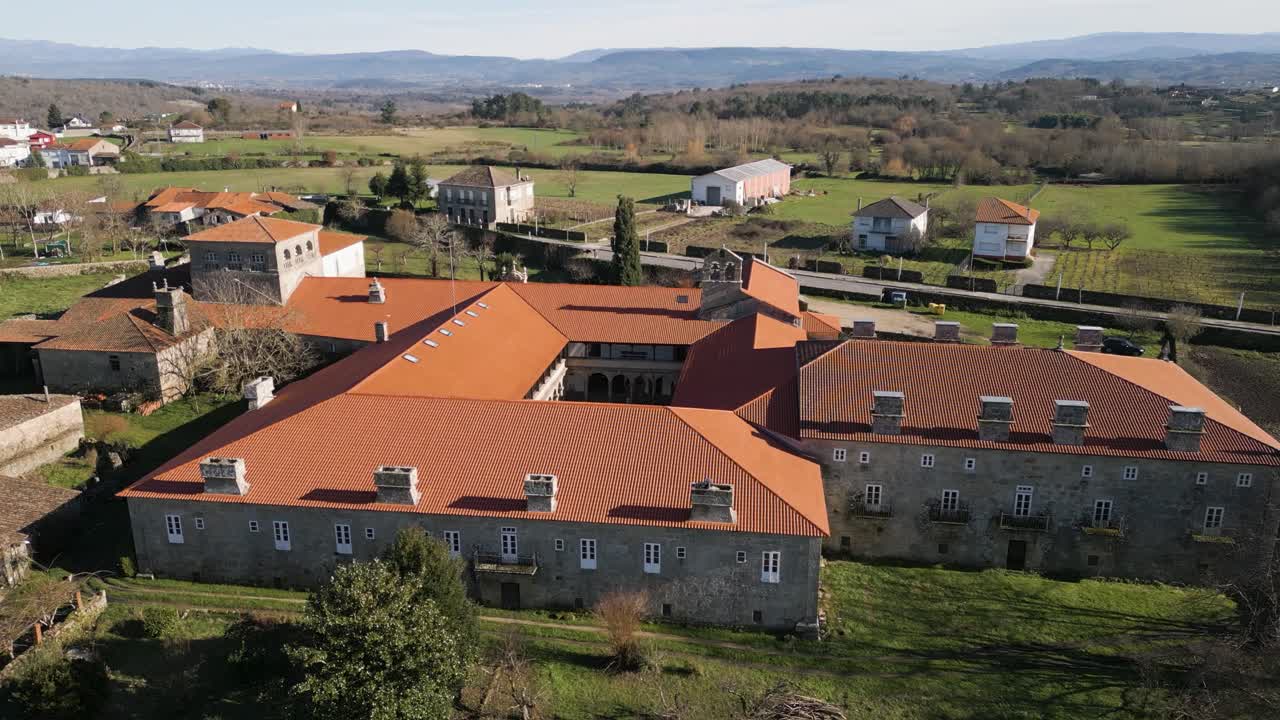 Dolly aereo sopra il tetto arancione e i camini nel monastero di San Salvador de Ferreira.