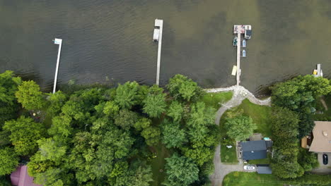 Top-down-trucking-pan-across-private-docks-along-lake-shore-of-luxury-vacation-spot-in-the-mountains