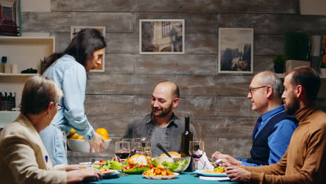 Young-woman-bringing-a-basket-of-fruits-at-family-dinner