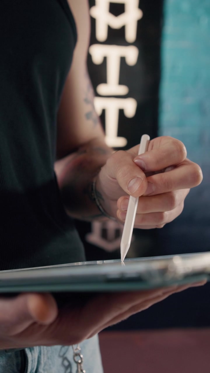 Tattoo Artist Designing on Digital Tablet in Studio