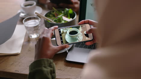 business woman using smartphone taking photo of coffee on mobile phone camera sharing lifestyle on social media enjoying relaxing in cafe close up hands