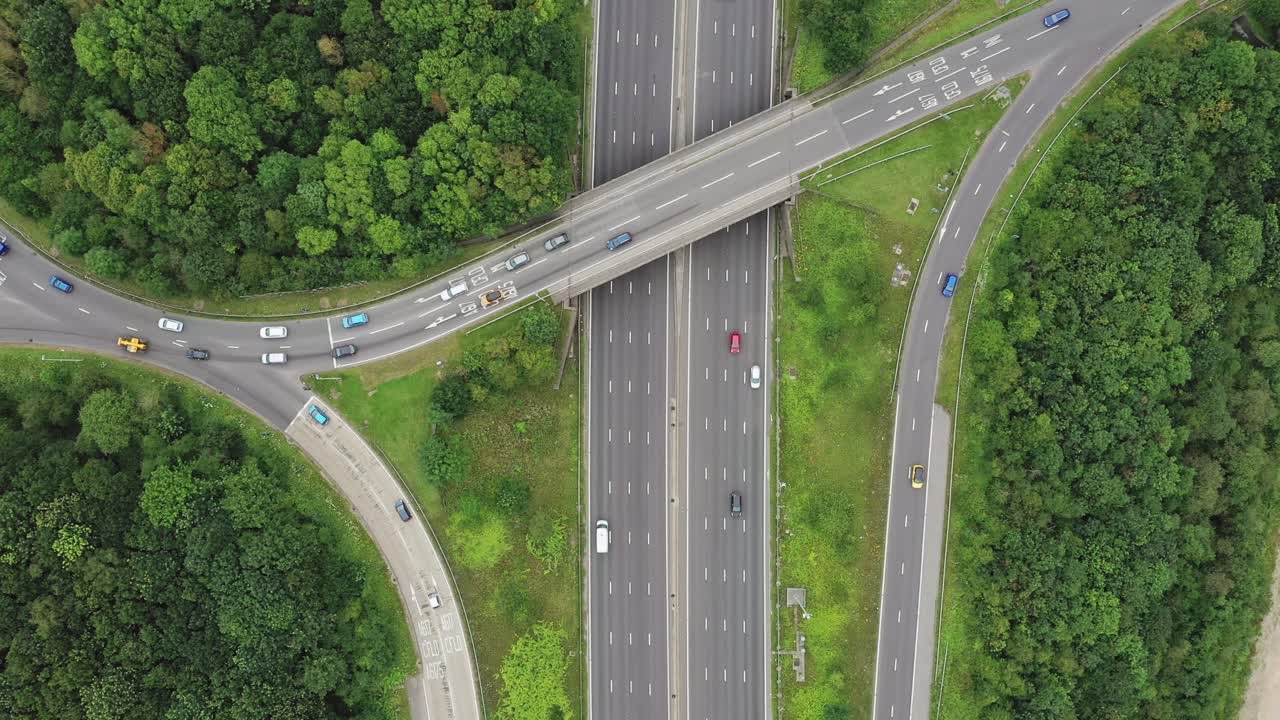 Birdseye drone aerial view over the motorway over a busy junction with a slow pull-out lift