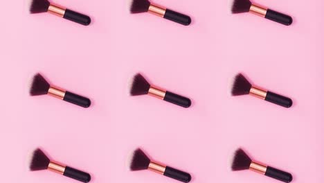 el patrón de concepto de belleza hecho de pinceles de maquillaje gira sobre un fondo rosa brillante. detenga el movimiento