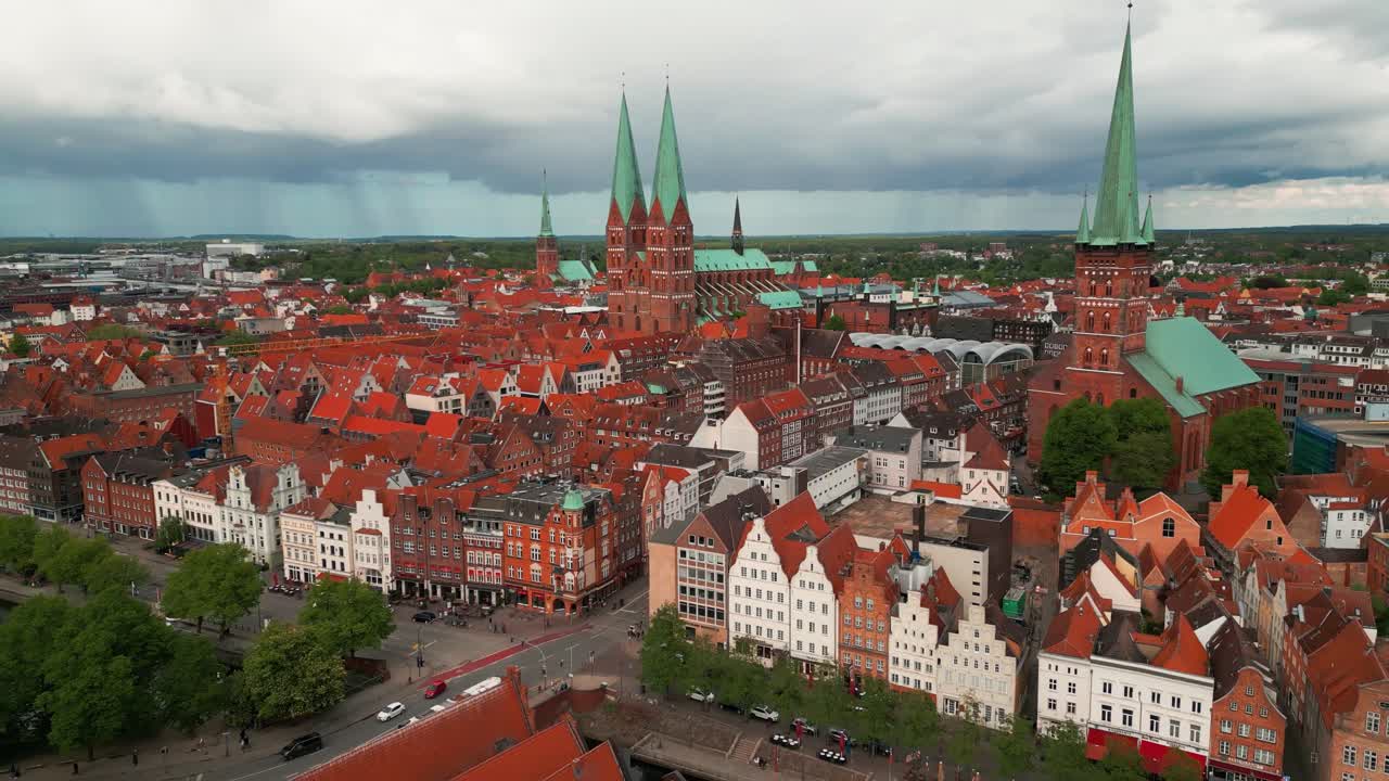 aerial shot going backward revealing Lubeck city center with saint marie and saint peter churches, the trave river and the holstentor gothic gate, Schleswig-Holstein land, Germany