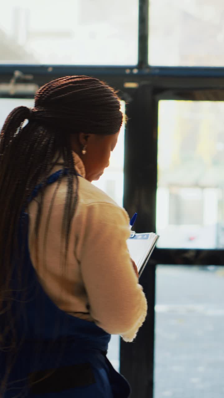 Vertical video: African american woman checking products on racks
