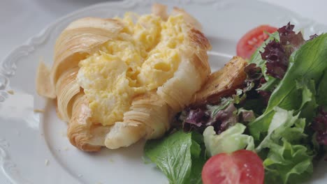 croissant with eggs and salad breakfast