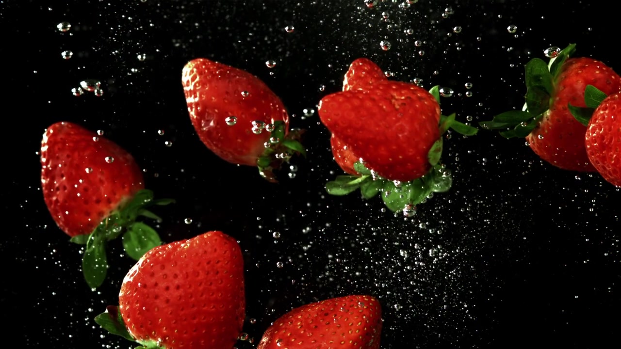 Fragole rosse fresche che galleggiano nell'acqua con bolle