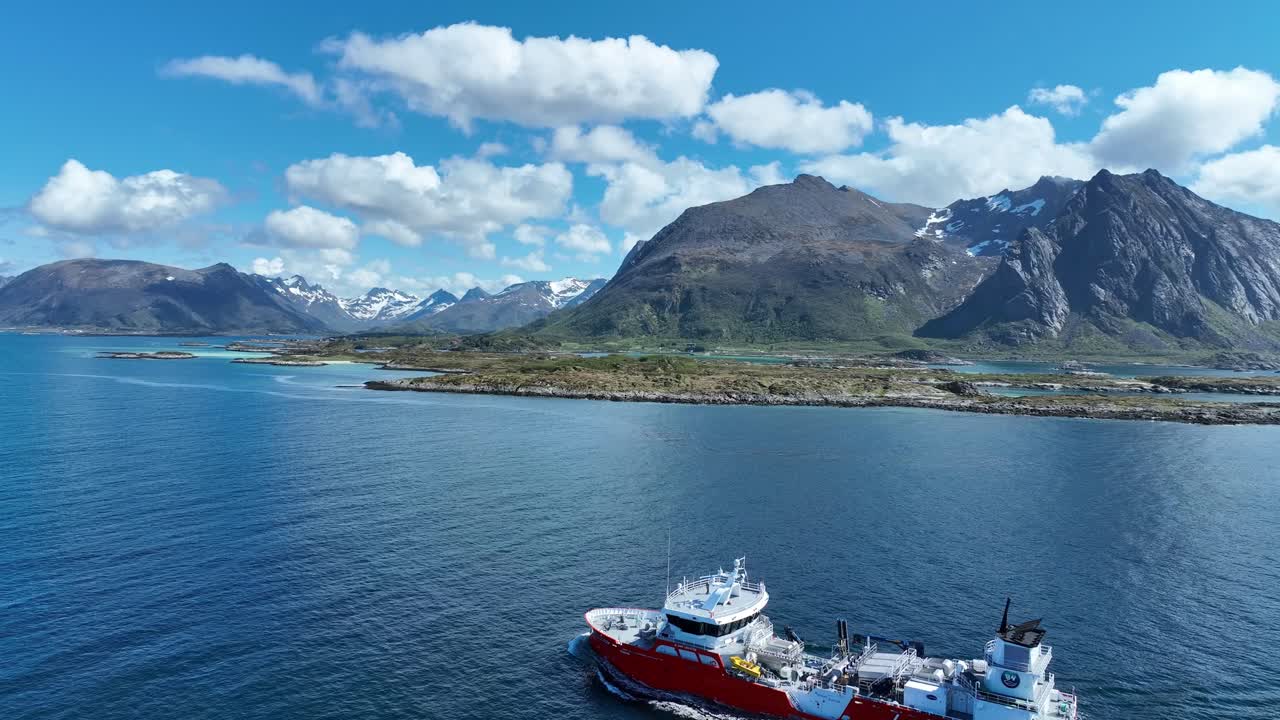 Drone circles close to wellboat as it sails through Gimsoystraumen with Hartinden ahead