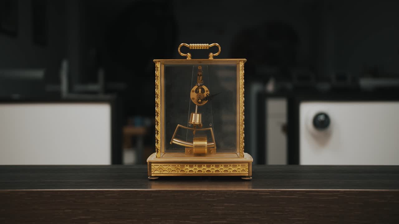 A gold designed transparent desk clock displayed on a wooden table - mid shot