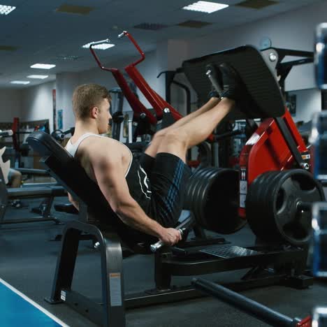 un joven atleta entrena sus piernas en el gimnasio 1