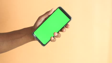 teléfono inteligente en la mano con pantalla verde
