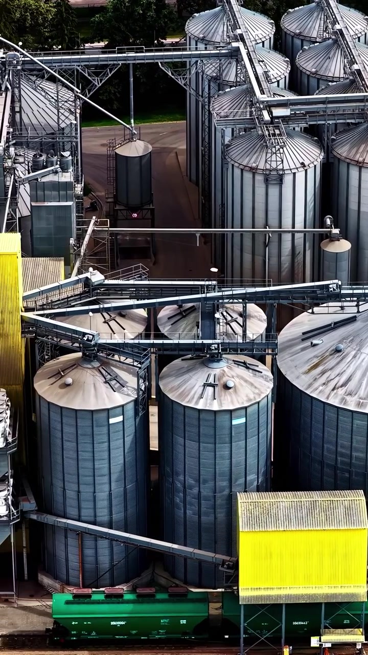 Große Industriesilos und gelbe Strukturen auf einem Lagergelände. Perfekt zur Veranschaulichung industrieller Abläufe oder Logistikthemen.