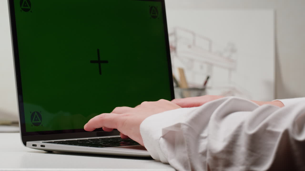 녹색 화면으로 노트북에서 타이핑하는 사람