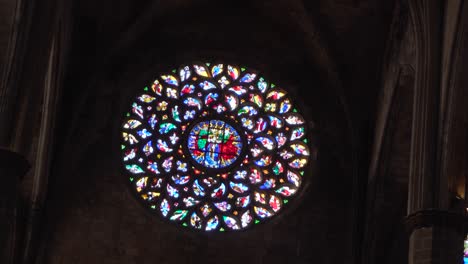 vidriera redonda y colorida en la basílica oscura de santa del mar, barcelona