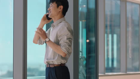 asian businessman using smartphone chatting to client financial advisor negotiating business deal corporate sales executive sharing expert advice having phone call in office looking out window