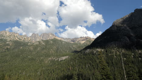 traveling view of cascade mountain range landscape with pine trees in foreground