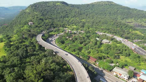 aerial view of winding highway through lush green mountains