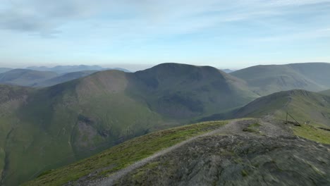 lone mountain walker on fell summit at golden hour