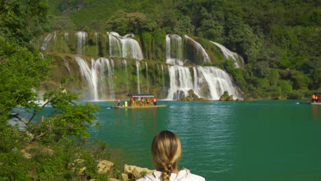 rear view of confident woman tourist watching ban gioc waterfall