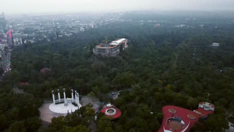 camión de vista aérea a la izquierda del castillo de chapultepec rodeado de árboles frondosos en un día completamente nebuloso en la ciudad de méxico
