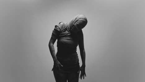 a mummified woman against the bright background moves erratically