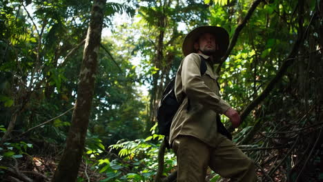 man hiking through lush jungle